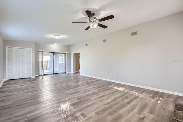 1175 Tracy Dr, Port Orange, FL 32129 - unfurnished bedroom featuring arched walkways, wood finished floors, two closets, and ceiling fan