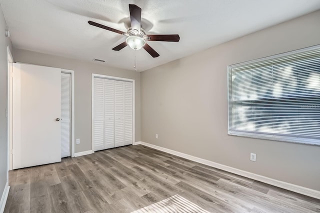 1175 Tracy Dr, Port Orange, FL 32129 - unfurnished bedroom featuring multiple closets, wood finished floors, and a ceiling fan