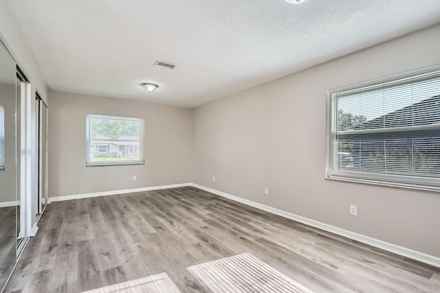 1175 Tracy Dr, Port Orange, FL 32129 - unfurnished bedroom with wood finished floors and a textured ceiling