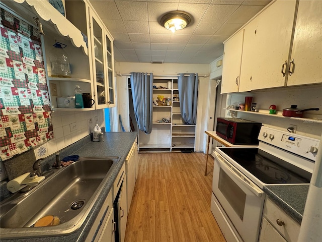 207 E Orange St, Kissimmee, FL 34744 - kitchen featuring white electric stove, white cabinets, dark countertops, light wood finished floors, and open shelves
