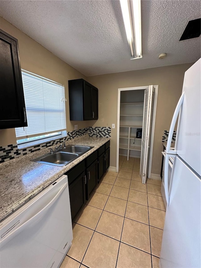 1918 Honour Rd Unit 4, Orlando, FL 32839 - kitchen featuring white appliances, dark cabinetry, a textured ceiling, light tile patterned floors, and light countertops