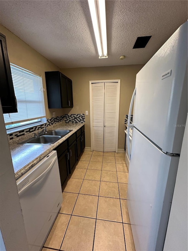 1918 Honour Rd Unit 4, Orlando, FL 32839 - kitchen featuring white appliances, a textured ceiling, light tile patterned floors, and dark cabinets