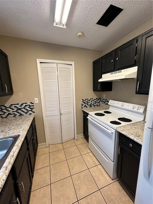 1918 Honour Rd Unit 4, Orlando, FL 32839 - kitchen with under cabinet range hood, white range with electric cooktop, dark cabinetry, a textured ceiling, and light tile patterned floors