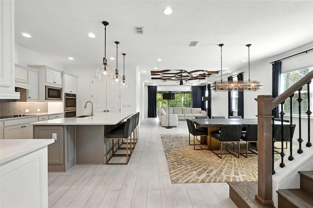 15315 Gilligan Ct, Winter Garden, FL 34787 - kitchen with built in microwave, plenty of natural light, light countertops, a kitchen island with sink, and recessed lighting