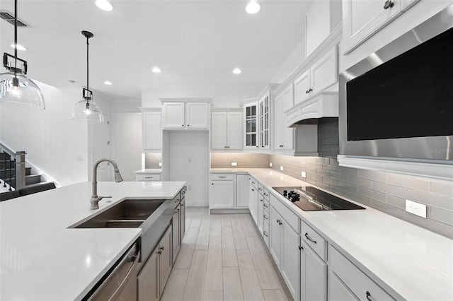 15315 Gilligan Ct, Winter Garden, FL 34787 - kitchen with stainless steel appliances, light countertops, hanging light fixtures, white cabinetry, and recessed lighting