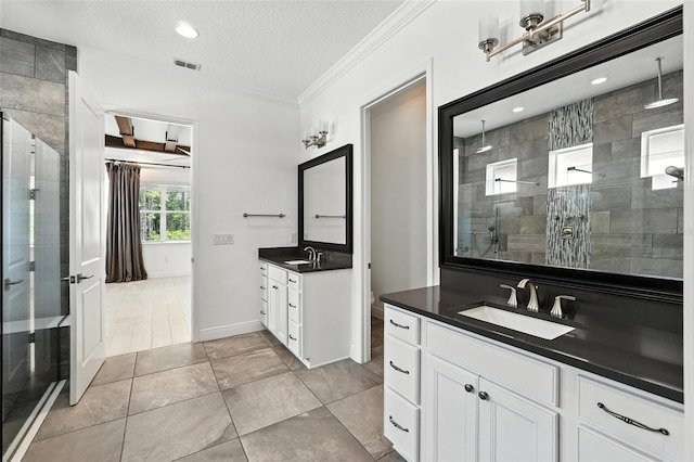 15315 Gilligan Ct, Winter Garden, FL 34787 - full bath featuring a shower stall, two vanities, ornamental molding, a textured ceiling, and tile patterned floors