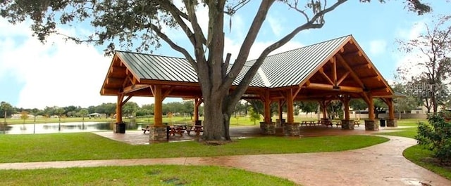 view of community with a gazebo, a water view, and a lawn