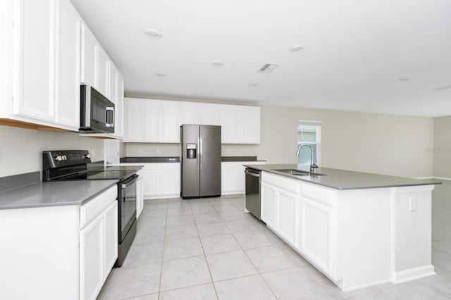 4288 Blackshear Ct, Clermont, FL 34714 - kitchen with stainless steel appliances, white cabinets, light tile patterned flooring, an island with sink, and dark countertops