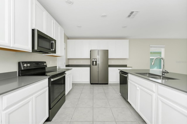 4288 Blackshear Ct, Clermont, FL 34714 - kitchen with stainless steel appliances, white cabinetry, light tile patterned floors, and dark countertops