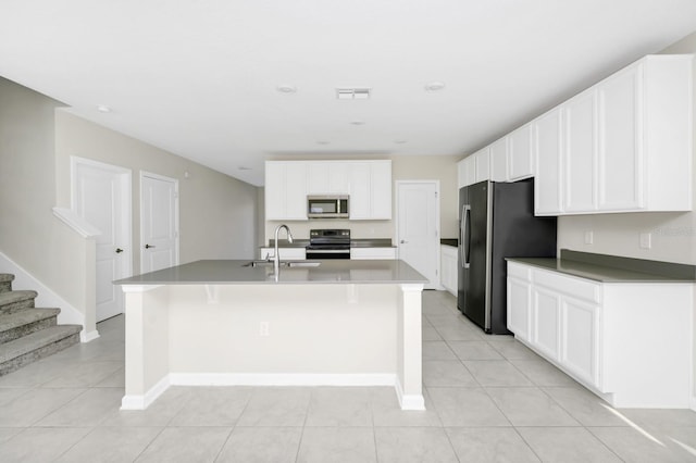 4288 Blackshear Ct, Clermont, FL 34714 - kitchen featuring stainless steel microwave, freestanding refrigerator, electric stove, a kitchen island with sink, and white cabinets