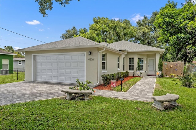 4636 Piedmont St, Orlando, FL 32811 - view of front of home with stucco siding, an attached garage, and decorative driveway