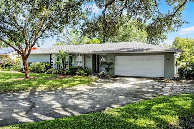 7201 Pleasant Dr, Orlando, FL 32818 - single story home featuring stucco siding, driveway, an attached garage, and a front lawn