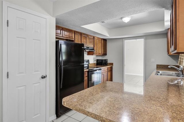 7201 Pleasant Dr, Orlando, FL 32818 - kitchen with black appliances, light tile patterned flooring, under cabinet range hood, a textured ceiling, and brown cabinetry