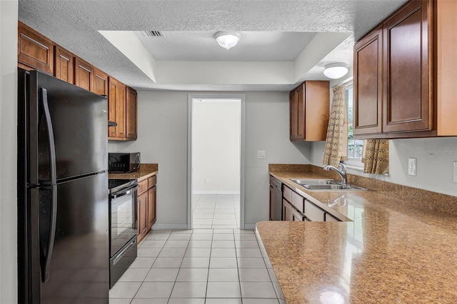 7201 Pleasant Dr, Orlando, FL 32818 - kitchen with black appliances, a textured ceiling, light tile patterned floors, a tray ceiling, and brown cabinets