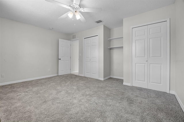 7201 Pleasant Dr, Orlando, FL 32818 - unfurnished bedroom with multiple closets, carpet, a textured ceiling, and a ceiling fan