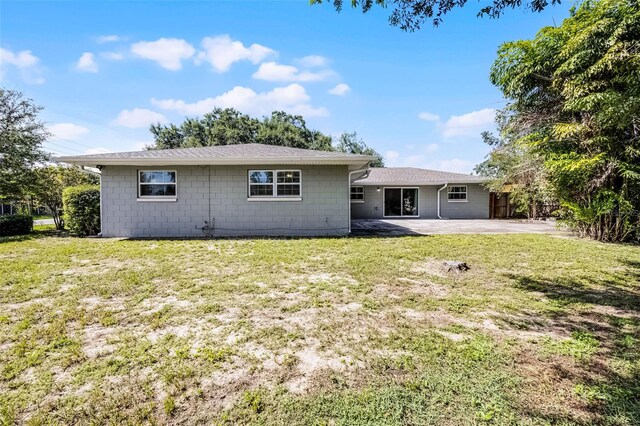 7201 Pleasant Dr, Orlando, FL 32818 - back of house with a patio area, a yard, roof with shingles, and concrete block siding