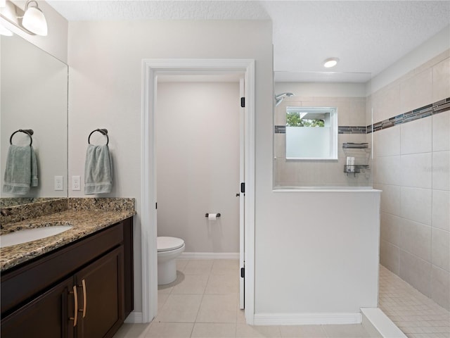 2556 Ocoee Reserve Ct, Ocoee, FL 34761 - bathroom featuring a walk in shower, vanity, tile patterned floors, and a textured ceiling