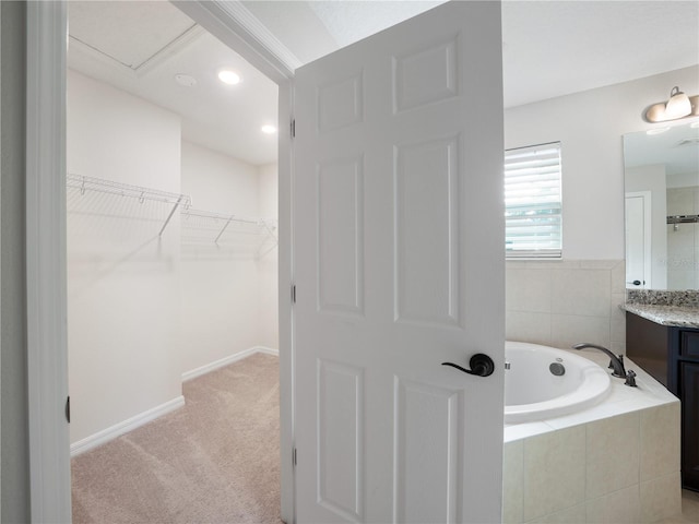 2556 Ocoee Reserve Ct, Ocoee, FL 34761 - bathroom featuring vanity, a bath, a walk in closet, and recessed lighting