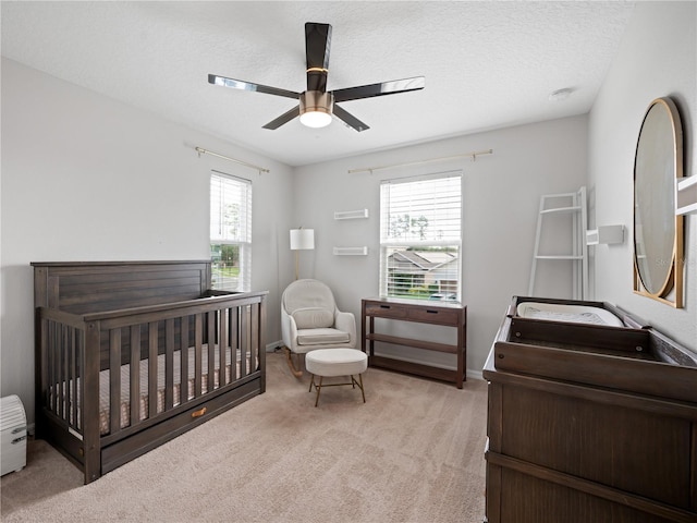 2556 Ocoee Reserve Ct, Ocoee, FL 34761 - bedroom featuring light carpet, a crib, a ceiling fan, and a textured ceiling