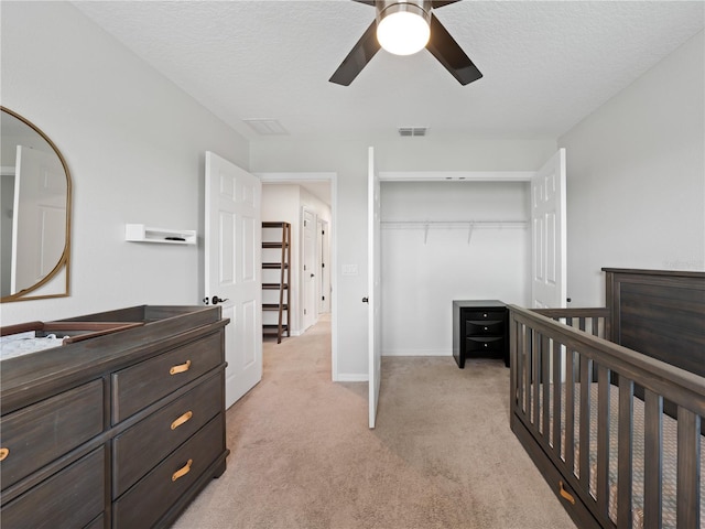 2556 Ocoee Reserve Ct, Ocoee, FL 34761 - bedroom featuring light colored carpet, a closet, a ceiling fan, and a textured ceiling