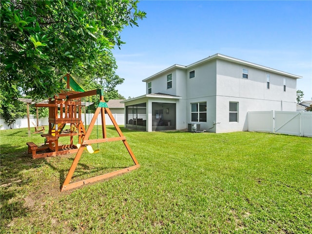 2556 Ocoee Reserve Ct, Ocoee, FL 34761 - back of property with a playground, a sunroom, a fenced backyard, a gate, and stucco siding