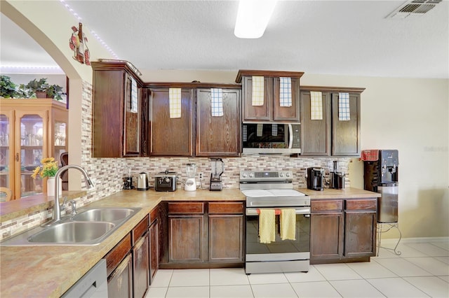 1514 Tamarind Rd, Davenport, FL 33896 - kitchen featuring stainless steel appliances, backsplash, light countertops, and arched walkways