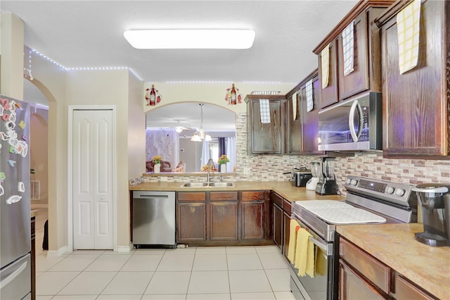 1514 Tamarind Rd, Davenport, FL 33896 - kitchen with stainless steel appliances, arched walkways, light countertops, and tasteful backsplash