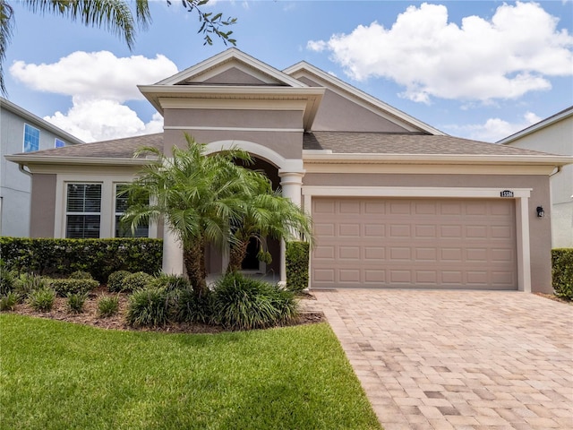 15586 Hamlin Blossom Ave, Winter Garden, FL 34787 - view of front of home featuring stucco siding, decorative driveway, a front yard, an attached garage, and a shingled roof