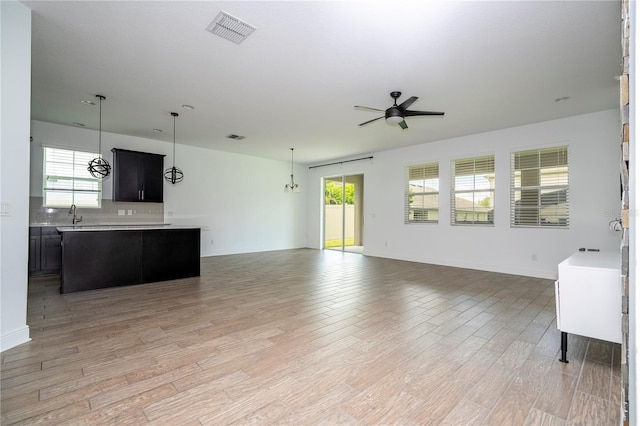 15586 Hamlin Blossom Ave, Winter Garden, FL 34787 - unfurnished living room featuring a ceiling fan and light wood-style flooring