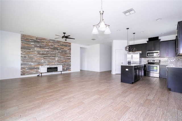 15586 Hamlin Blossom Ave, Winter Garden, FL 34787 - kitchen with stainless steel appliances, open floor plan, a center island, a ceiling fan, and light countertops