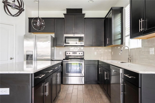 15586 Hamlin Blossom Ave, Winter Garden, FL 34787 - kitchen featuring stainless steel appliances, wood finished floors, decorative backsplash, and a center island
