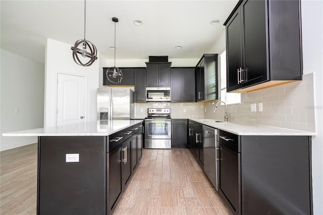 15586 Hamlin Blossom Ave, Winter Garden, FL 34787 - kitchen featuring stainless steel appliances, light wood-type flooring, backsplash, a center island, and pendant lighting