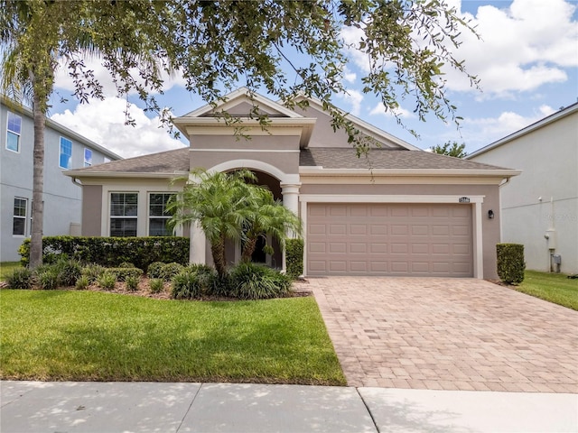 15586 Hamlin Blossom Ave, Winter Garden, FL 34787 - view of front of home featuring stucco siding, decorative driveway, a front yard, and an attached garage