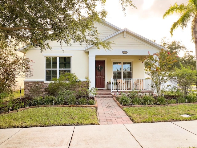 8004 Sweet Orange Ave, Winter Garden, FL 34787 - view of front of home featuring covered porch, stucco siding, and stone siding