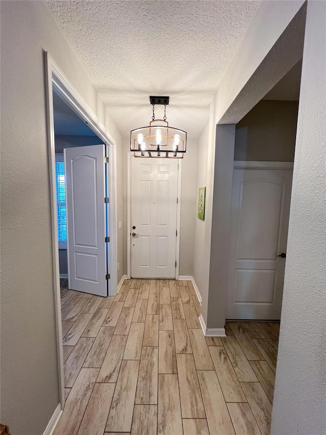 8004 Sweet Orange Ave, Winter Garden, FL 34787 - foyer featuring light wood-style flooring, a textured ceiling, and a chandelier