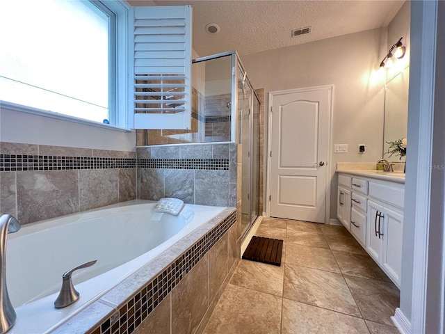 8004 Sweet Orange Ave, Winter Garden, FL 34787 - bathroom featuring vanity, a garden tub, a shower stall, a textured ceiling, and tile patterned flooring