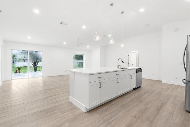 4527 Bamonte St, North Port, FL 34286 - kitchen featuring appliances with stainless steel finishes, light wood-style floors, open floor plan, a center island with sink, and light countertops