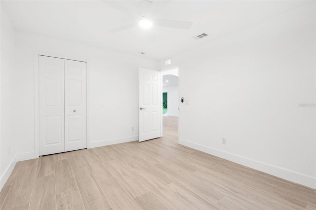 4527 Bamonte St, North Port, FL 34286 - unfurnished bedroom featuring light wood-style flooring, a closet, arched walkways, and a ceiling fan
