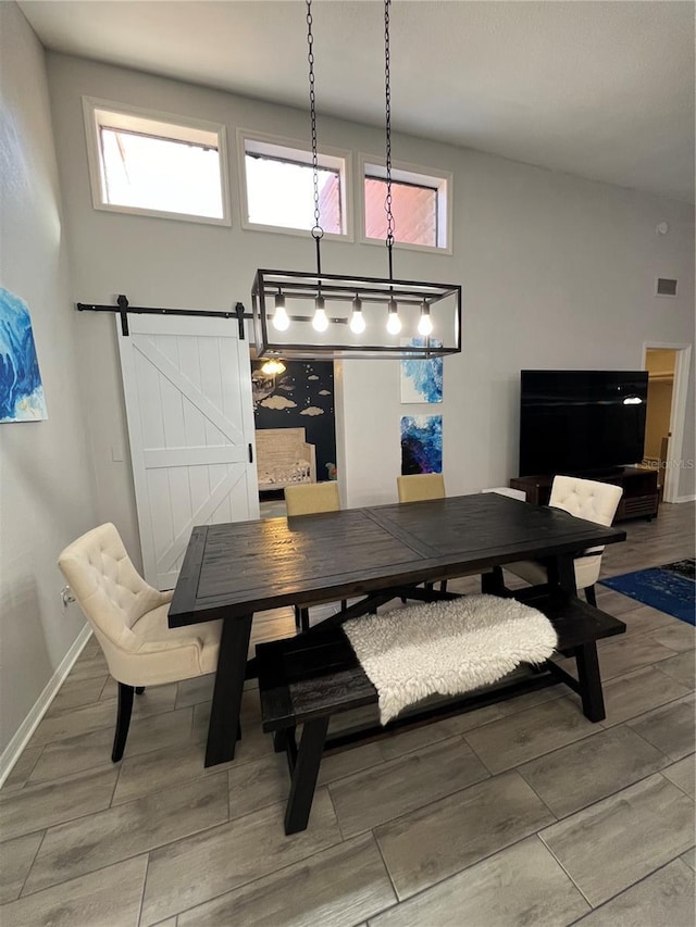 1159 E Winged Foot Cir, Winter Springs, FL 32708 - dining room featuring a barn door, light wood finished floors, and a high ceiling