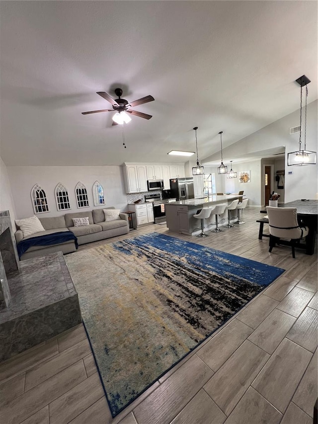 1159 E Winged Foot Cir, Winter Springs, FL 32708 - living room with wood tiled floors, a ceiling fan, and vaulted ceiling