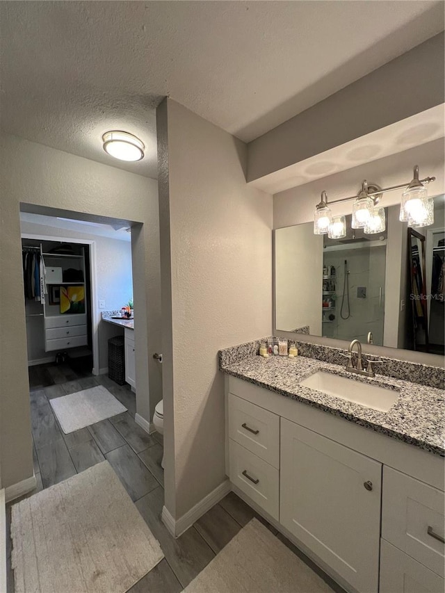 1159 E Winged Foot Cir, Winter Springs, FL 32708 - full bath with vanity, a spacious closet, a shower, a textured wall, and wood finished floors