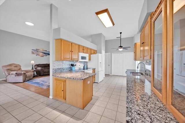 422 Harbourview Dr, Haines City, FL 33844 - kitchen with white appliances, high vaulted ceiling, light tile patterned flooring, a ceiling fan, and a peninsula