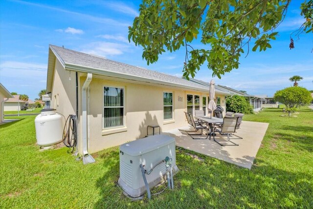 422 Harbourview Dr, Haines City, FL 33844 - rear view of property with a patio, a yard, stucco siding, and roof with shingles