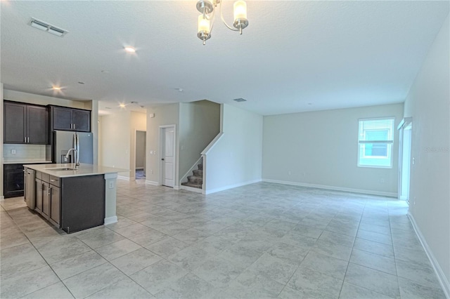 7524 Summerlake Groves St, Winter Garden, FL 34787 - kitchen with stainless steel fridge with ice dispenser, open floor plan, light countertops, an island with sink, and a textured ceiling