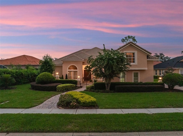 8974 Grey Hawk Pt, Orlando, FL 32836 - mediterranean / spanish home featuring stucco siding, a front lawn, and a tile roof