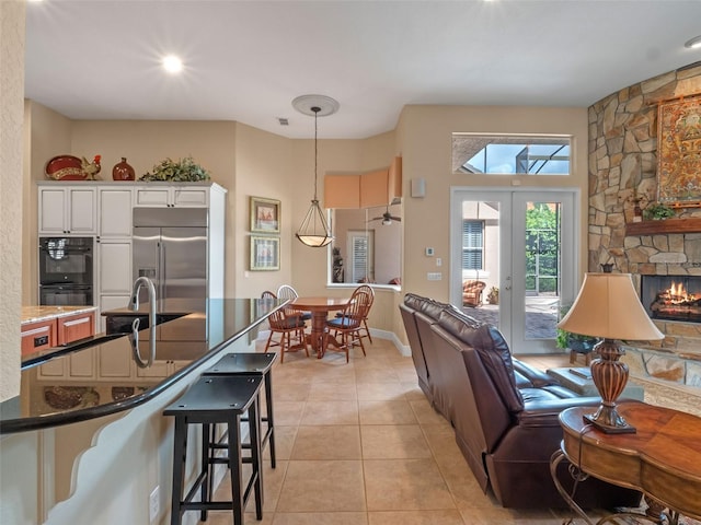 8974 Grey Hawk Pt, Orlando, FL 32836 - kitchen featuring built in fridge, a kitchen breakfast bar, open floor plan, white cabinetry, and decorative light fixtures