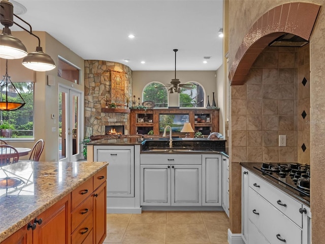 8974 Grey Hawk Pt, Orlando, FL 32836 - kitchen with black gas cooktop, a ceiling fan, light tile patterned floors, a peninsula, and open floor plan