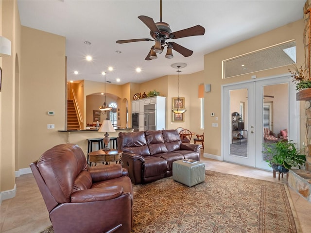 8974 Grey Hawk Pt, Orlando, FL 32836 - living room with french doors, stairs, a ceiling fan, light tile patterned floors, and arched walkways