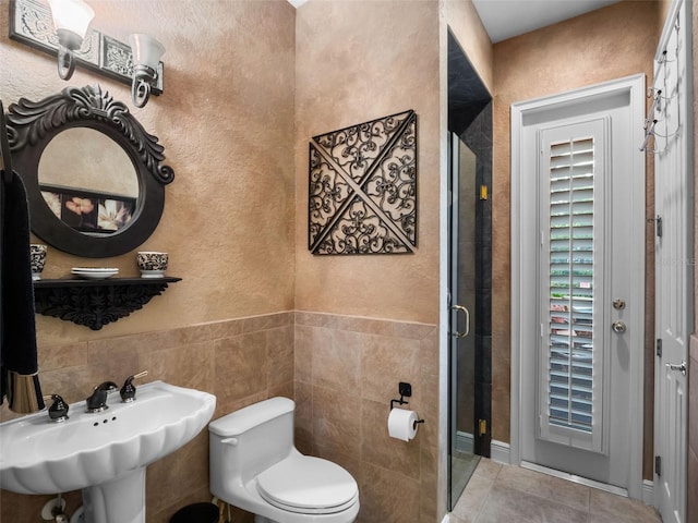 8974 Grey Hawk Pt, Orlando, FL 32836 - full bathroom featuring a shower stall, tile patterned floors, a textured wall, and tile walls