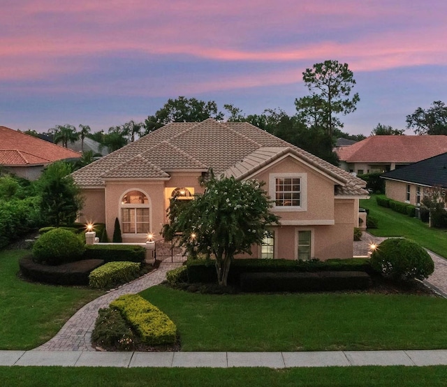 8974 Grey Hawk Pt, Orlando, FL 32836 - mediterranean / spanish-style house with a lawn, a tile roof, and stucco siding
